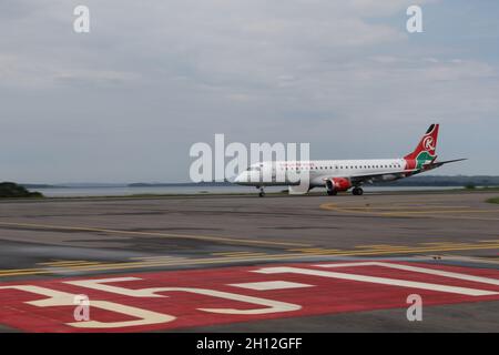 (211015) -- ENTEBBE (UGANDA), 15. Oktober 2021 (Xinhua) -- Ein Flugzeug von Kenya Airways nimmt am 6. Oktober 2021 ein Taxi auf die neu gepflasterte Start- und Landebahn des Entebbe International Airport in Entebbe, Uganda. Auf dem Asphalt des ugandischen Entebbe International Airport am Ufer des Viktoriasees legen chinesische Techniker und ihre ugandischen Kollegen beim ein- und Ausfliegen der Flugzeuge den letzten Schliff auf die Schürzen. Der 70 Jahre alte Flughafen, der 1951 von den britischen Kolonialmeistern eröffnet, Anfang der 1970er Jahre renoviert und jetzt von China finanziert wird, ist Ugandas Haupttor zur Welt. (Xinhua/Zhang Ga Stockfoto