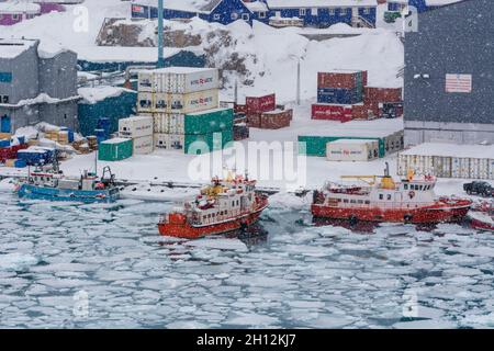 Fischerboote im gefrorenen Hafen während eines Schneesturms. Ilulissat, Grönland. Stockfoto