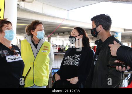 Wellington, Neuseeland. 16. Oktober 2021. Die neuseeländische Premierministerin Jacinda Ardern, zweite von rechts, mit ihrer Partnerin Clarke Gayford (ganz rechts) lacht mit Impfern bei einer Fahrt durch das Impfzentrum Covid-19, das im Sky Stadium für den „Super Saturday Vaxathon“ eingerichtet wurde. Quelle: Lynn Grieveson/Alamy Live News Stockfoto