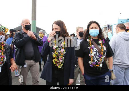 Porirua, Wellington, Neuseeland. 16. Oktober 2021: Die neuseeländische Premierministerin Jacinda Ardern (Mitte) und die stellvertretende Gesundheitsministerin Dr. Ayesha Verrall, sowohl mit Leis als auch mit Gesichtsmasken, bei einem Community-Impffestival im Cannons Creek in Porirua - Teil der Veranstaltung „Super Saturday Vaxathon“, die die Aufnahme von Covid-19-Impfstoffen erhöhen soll, Vor allem unter den Maori- und pazifischen Inselbewohnern in benachteiligten Gebieten, da Neuseeland mit einem Ausbruch der Delta-Variante kämpft. Quelle: Lynn Grieveson/Alamy Live News Stockfoto