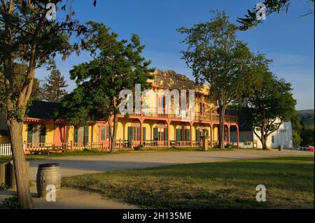 Ein glühender Sonnenuntergang in der Plaza Hall neben der historischen Mission San Juan Bautista CA Stockfoto