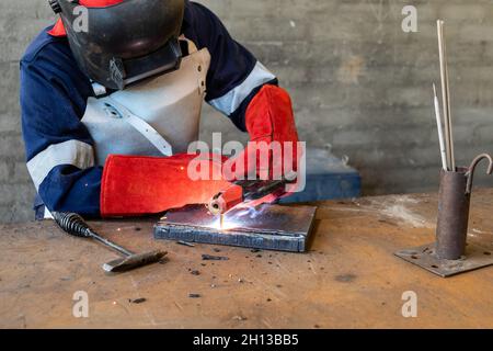 Motswana Schweißgerät Arbeiter in einer Botswana Workshop, Schweißen zwei Teile aus Metall Stockfoto