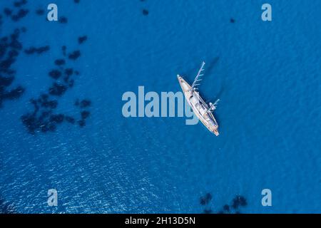 Lefkada, Griechenland. Abgelegener weißer Egremni-Strand mit einsamem Luxus-Yacht-Boot an der türkisfarbenen Bucht am Ionischen Meer Stockfoto