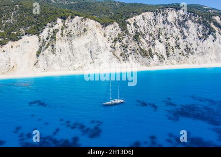 Lefkada, Griechenland. Abgelegener weißer Egremni-Strand mit einsamem Luxus-Yacht-Boot an der türkisfarbenen Bucht am Ionischen Meer Stockfoto