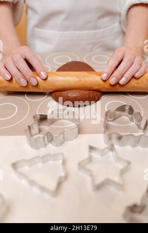 Frau knetet Teig zum Backen von Weihnachts-Lebkuchen mit Nudelholz. Stockfoto