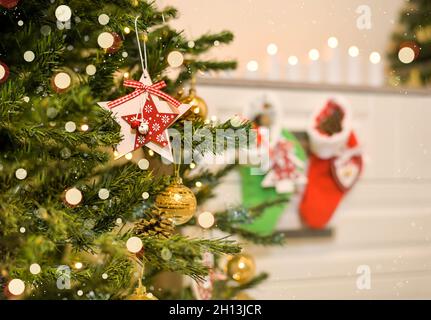 Ein dekorativer Stern auf einem Weihnachtsbaum in einem festlich dekorierten Raum. Stockfoto