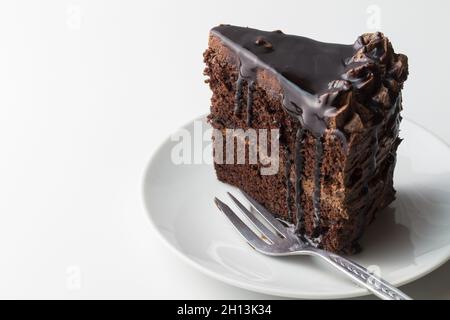 Stück Schokoladenkuchen auf Weiß mit Kuchengabel und Platz für Text Stockfoto