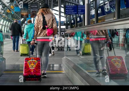 Schkeuditz, Deutschland. Oktober 2021. Reisende checken am Flughafen Leipzig/Halle mit ihrem Gepäck ein. Das erste Wochenende der Herbstferien in Sachsen ist eine geschäftige Zeit am Flughafen. Insgesamt starten am Samstag und Sonntag 50 Flugzeuge von den Flughäfen Leipzig/Halle und Dresden in Sachsen zu Urlaubszielen wie Spanien, der Türkei, Griechenland und Italien. Kredit: Peter Endig/dpa-Zentralbild/dpa/Alamy Live Nachrichten Stockfoto