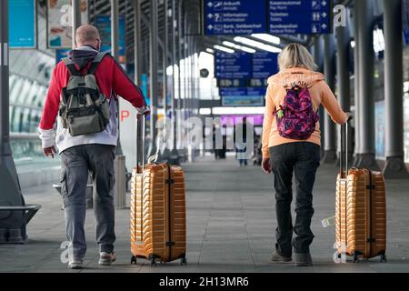 Schkeuditz, Deutschland. Oktober 2021. Reisende checken am Flughafen Leipzig/Halle mit ihrem Gepäck ein. Das erste Wochenende der Herbstferien in Sachsen ist eine geschäftige Zeit am Flughafen. Insgesamt starten am Samstag und Sonntag 50 Flugzeuge von den Flughäfen Leipzig/Halle und Dresden in Sachsen zu Urlaubszielen wie Spanien, der Türkei, Griechenland und Italien. Kredit: Peter Endig/dpa-Zentralbild/dpa/Alamy Live Nachrichten Stockfoto