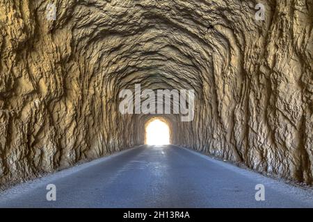 Helles Licht am Ende des Tunnels. Uralter Tunnel mit rauhen Wänden. Stockfoto