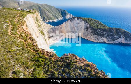 Luftaufnahme des Navagio Beach - Shipwreck Beach - auf der Insel Zakynthos, Griechenland. Touristen auf Klippe genießen die Aussicht auf Sommer Reise Stockfoto