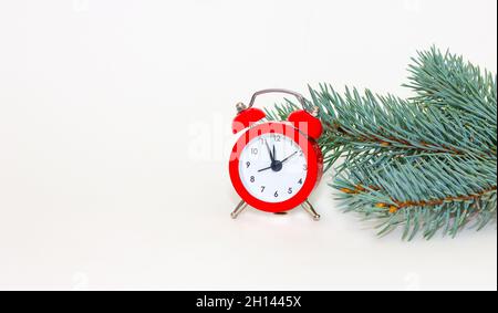 Retro mit rotem Wecker und Tannenzweigen für Konzeptdesign. Weihnachten und Neujahr Stockfoto