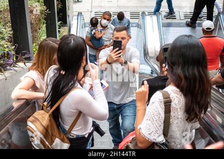 Medellin, Antioquia Kolumbien - Januar 6 2021: Kaukasischer männlicher Tourist schießt Gruppenfoto von weiblichen Freunden in mechanischer Treppe Stockfoto