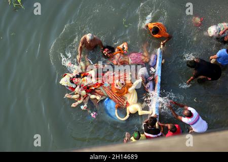 Dhaka, Bangladesch. Oktober 2021. Hinduistische Anhänger tauchen am letzten Tag des Durga Puja-Festivals ein Lehmidol der Hindu-Göttin Durga im Buriganga-Fluss ein. Das größte religiöse Fest der Hindu-Gemeinde Bangalee endete am Freitag mit dem Eintauchen der Idole der Göttin Durga und ihrer Kinder entlang des Flusses. Am 15. Oktober 2021 in Dhaka, Bangladesch. (Foto von Habibur Rahman/ Eyepix Group) Quelle: Eyepix Group/Alamy Live News Stockfoto