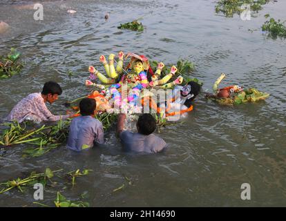 Dhaka, Bangladesch. Oktober 2021. Hinduistische Anhänger tauchen am letzten Tag des Durga Puja-Festivals ein Lehmidol der Hindu-Göttin Durga im Buriganga-Fluss ein. Das größte religiöse Fest der Hindu-Gemeinde Bangalee endete am Freitag mit dem Eintauchen der Idole der Göttin Durga und ihrer Kinder entlang des Flusses. Am 15. Oktober 2021 in Dhaka, Bangladesch. (Foto von Habibur Rahman/ Eyepix Group) Quelle: Eyepix Group/Alamy Live News Stockfoto