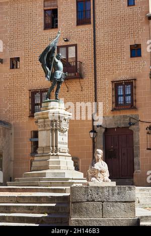 Die Juan Bravo Statue mit dem Turm des Lozoya Palastes im Hintergrund. Segovia, Spanien. Stockfoto