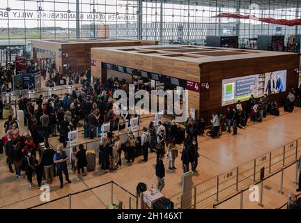 Berlin, Deutschland. Oktober 2021. 16. Oktober 2021, Schönefeld: Reisende stehen dicht beieinander vor einem Check-in-Schalter am Flughafen BER. Foto: Paul Zinken/dpa Kredit: dpa picture Alliance/Alamy Live News Stockfoto