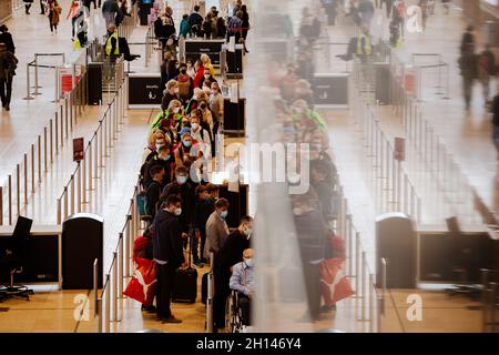 Berlin, Deutschland. Oktober 2021. 16. Oktober 2021, Brandenburg, Schönefeld: Reisende stehen dicht beieinander vor einem Check-in-Schalter am Flughafen BER. Foto: Paul Zinken/dpa Kredit: dpa picture Alliance/Alamy Live News Stockfoto