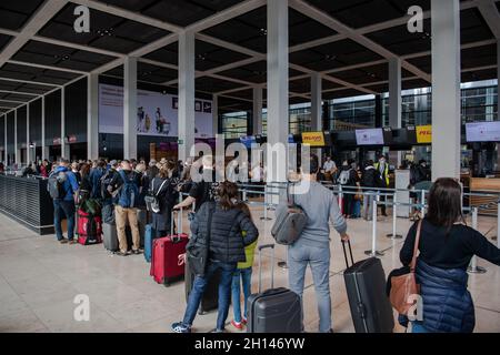 Berlin, Deutschland. Oktober 2021. 16. Oktober 2021, Schönefeld: Reisende stehen dicht beieinander vor einem Check-in-Schalter am Flughafen BER. Foto: Paul Zinken/dpa Kredit: dpa picture Alliance/Alamy Live News Stockfoto