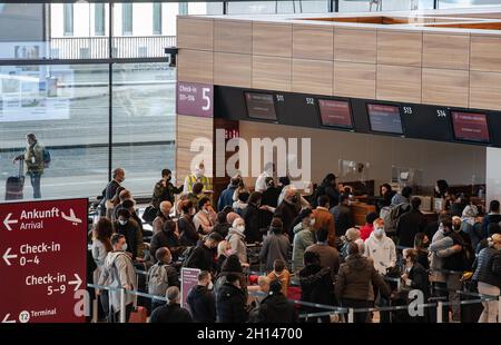 Berlin, Deutschland. Oktober 2021. 16. Oktober 2021, Brandenburg, Schönefeld: Reisende stehen dicht beieinander vor einem Check-in-Schalter am Flughafen BER. Foto: Paul Zinken/dpa Kredit: dpa picture Alliance/Alamy Live News Stockfoto