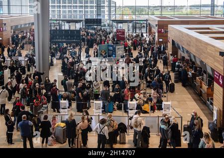 Berlin, Deutschland. Oktober 2021. 16. Oktober 2021, Brandenburg, Schönefeld: Reisende stehen dicht beieinander vor einem Check-in-Schalter am Flughafen BER. Foto: Paul Zinken/dpa Kredit: dpa picture Alliance/Alamy Live News Stockfoto