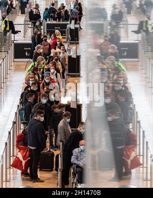 Berlin, Deutschland. Oktober 2021. 16. Oktober 2021, Brandenburg, Schönefeld: Reisende stehen dicht beieinander vor einem Check-in-Schalter am Flughafen BER. Foto: Paul Zinken/dpa Kredit: dpa picture Alliance/Alamy Live News Stockfoto