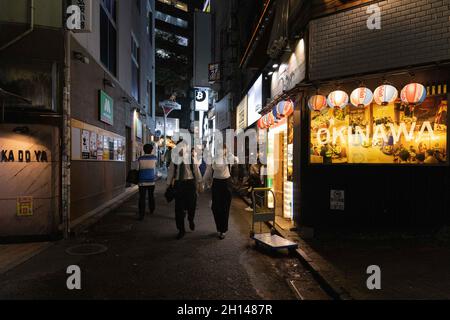 Tokio, Japan. Oktober 2021. Maskierte Menschen gehen durch eine Gasse im Shibuya-Viertel in Tokio.das Nachtleben im Unterhaltungsviertel von Tokio Shibuya normalisiert sich wieder, nachdem der mit dem Coronavirus verbundene Ausnahmezustand in Tokio aufgehoben wurde. Restaurants und Bars können abends geöffnet sein und wieder Alkohol servieren. Kredit: SOPA Images Limited/Alamy Live Nachrichten Stockfoto