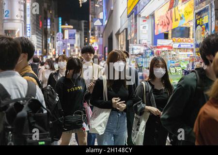 Tokio, Japan. Oktober 2021. Menschen, die Gesichtsmasken tragen, gehen durch die belebten Straßen des Shibuya-Viertels in Tokio.das Nachtleben im Unterhaltungsviertel von Tokio Shibuya kehrt wieder zur Normalität zurück, nachdem der mit dem Coronavirus verbundene Ausnahmezustand in Tokio aufgehoben wurde. Restaurants und Bars können abends geöffnet sein und wieder Alkohol servieren. (Foto: Stanislav Kogiku/SOPA Images/Sipa USA) Quelle: SIPA USA/Alamy Live News Stockfoto