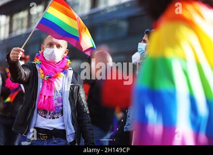 Düsseldorf, Deutschland. Oktober 2021. Ein Teilnehmer der Christopher Street Day Kundgebung winkt mit einer Regenbogenfahne. Dieses Jahr steht das Motto „Solidarität hat viele Farben“. Die Aktionen des Christopher Street Day (CSD) erinnern jedes Jahr an eine Reihe gewalttätiger Konflikte zwischen Homosexuellen und Polizisten in der Christopher Street in New York im Jahr 1969. Quelle: Oliver Berg/dpa/Alamy Live News Stockfoto