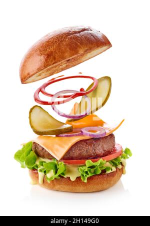 Burger mit fliegenden Zutaten isoliert auf weißem Hintergrund Stockfoto