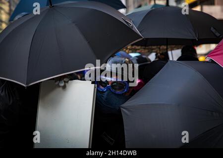 20. Oktober 2019, Hongkong, China: Demonstranten schützen sich während der Demonstration mit Regenschirmen vor Tränengas-Pellets und Plastikgeschossen der Polizei. Zahlreiche und massive Proteste brachen 2019 in Hongkong aus. Da das Auslieferungsgesetz ernsthafte Bedenken aufwirft, da die Hongkonger Behörden die nicht-verurteilte Beklagte nach China zurückleiten können, war dies als einer der größten zivilen Aufschreie nach der Übergabe Hongkongs an China im Jahr 1997 bekannt. Die Proteste eskalierten bald von friedlichen Demonstrationen zu gewalttätigen Zusammenstößen mit der Polizei im Juli. Tausende verhaftet, verletzt und jetzt hinter Gittern, wie die m Stockfoto