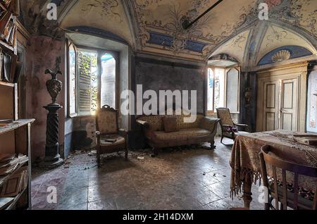 Wohnzimmer noch in einem verlassenen Haus eingerichtet. Urbex in Italien Stockfoto