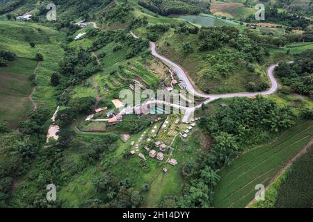 Luftaufnahme des Hüttenresort am Hang zwischen den Bergen im tropischen Regenwald an regnerischen Tagen in Thailand Stockfoto