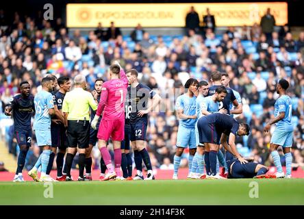 Burnley-Spieler appellieren an Schiedsrichter Martin Atkinson, da Teamkollege Dwight McNeil (rechts) während des Premier-League-Spiels im Etihad Stadium in Manchester auf dem Spielfeld nach einer Herausforderung durch Aymeric Laporte von Manchester City verletzt liegt. Bilddatum: Samstag, 16. Oktober 2021. Stockfoto