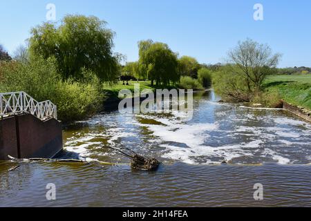 Eine attraktive ländliche Landschaft mit dem Wehr hinter der alten Wassermühle, wo das Wasser abfließt, um wieder in den Fluss Avon einzumünden. Stockfoto