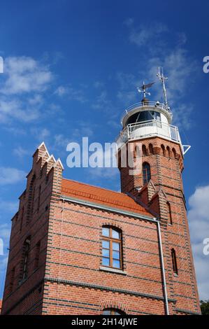 USTKA, POLEN - 06. Aug 2013: Das alte neugotische Leuchtturmgebäude an einem sonnigen Tag in Ustka, Polen Stockfoto