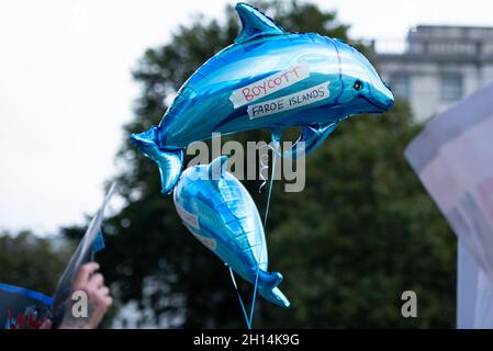 London, Großbritannien. Oktober 2021. Aktivisten halten Delphinballons bereit, die ihre Meinung während des Protestes zum Stoppen des Wals und zum Dolphin Slaughter äußern.Dominic Dyer, der Politikberater von Born Free, fordert jetzt Sanktionen, um das beschämende Schlachten von Walen und Delfinen auf den Färöer Inseln zu beenden. Die brutale Schlachtung von mehr als 1,400 Weißwanddelfinen auf den Färöer-Inseln hat weltweit enorme Wut und Empörung ausgelöst und wieder einmal die weltweite Aufmerksamkeit auf die lange und blutige Geschichte des Tötens von Walen und Delfinen in diesem wunderschönen, aber isolierten Archipel, 200 Meilen nordwestlich von Schottland, gelenkt. Kredit: SOPA Stockfoto