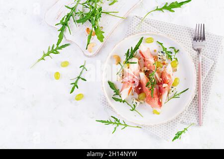 Vorspeise mit Birne, Blauschimmelkäse und Schinken für den Urlaub auf einem weißen Teller. Draufsicht, flach liegend Stockfoto