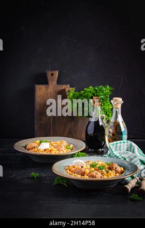 Italienische traditionelle Ditalini-Pasta mit Fleischbällchen in Tomatensauce und Gemüse in einer Schüssel. Ditalini-Nudeln und Rinderbällchen mit Marinara-Tomatensauce. Stockfoto