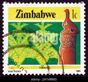 SIMBABWE - UM 1985: Eine in Simbabwe gedruckte Marke zeigt Zimbabwe Vogel und Tabak, Landwirtschaft, um 1985 Stockfoto