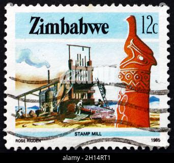 SIMBABWE - UM 1985: Eine in Simbabwe gedruckte Marke zeigt Zimbabwe Vogel- und Stempelmühle, Industrie, um 1985 Stockfoto