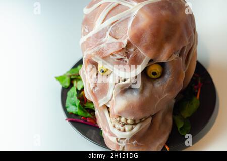 Kreativ zubereitetes Essen in Form eines unheimlichen Totenschädels, ein lustiges und Interessantes Essen, das für eine halloween-Party, Horroressen, serviert wird Stockfoto