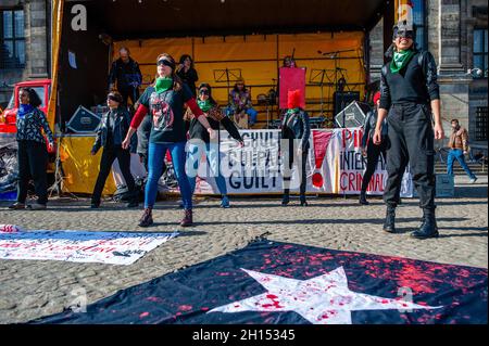 Eine Gruppe chilenischer Frauen wird während der Demonstration das aktivistische Lied The Rapist is You aufführen sehen. Am zweiten Jahrestag des sozialen Ausbruchs in Chile haben sich mehrere europäische soziale, politische und Menschenrechtsorganisationen zusammengeschlossen, um Wahrheit, Gerechtigkeit, Wiedergutmachung und Garantien für die Nichtwiederholungen der systematischen Menschenrechtsverletzungen durch chilenische Polizeibeamte zu fordern, die vom amtierenden chilenischen Präsidenten Sebastian Piñera unterstützt werden. In Amsterdam organisierte die chilenische Gemeinde eine Demonstration, die von Aufführungen und chilenischer Musik im Zentrum der Stadt begleitet wurde. Stockfoto