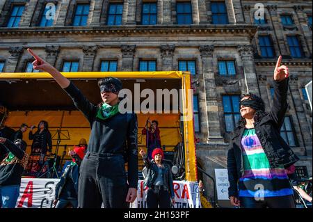 Eine Gruppe chilenischer Frauen wird während der Demonstration das aktivistische Lied The Rapist is You aufführen sehen. Am zweiten Jahrestag des sozialen Ausbruchs in Chile haben sich mehrere europäische soziale, politische und Menschenrechtsorganisationen zusammengeschlossen, um Wahrheit, Gerechtigkeit, Wiedergutmachung und Garantien für die Nichtwiederholungen der systematischen Menschenrechtsverletzungen durch chilenische Polizeibeamte zu fordern, die vom amtierenden chilenischen Präsidenten Sebastian Piñera unterstützt werden. In Amsterdam organisierte die chilenische Gemeinde eine Demonstration, die von Aufführungen und chilenischer Musik im Zentrum der Stadt begleitet wurde. Stockfoto