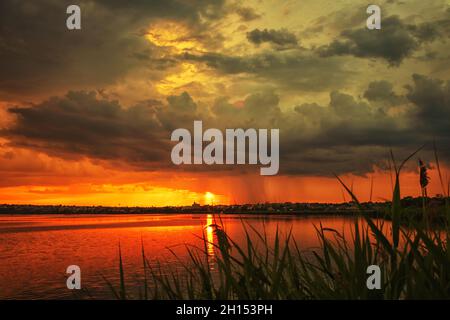 Sonnenuntergang auf dem See reeds Reflexionen und Wolken Stockfoto