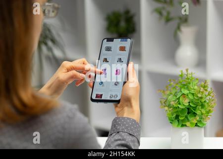 Frau mit Smartphone kauft online. E-Commerce über ein Mobiltelefon. Einkaufen. Stockfoto