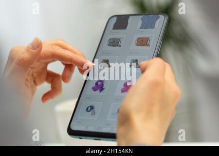 Frau mit Smartphone kauft online. E-Commerce über ein Mobiltelefon. Einkaufen. Stockfoto