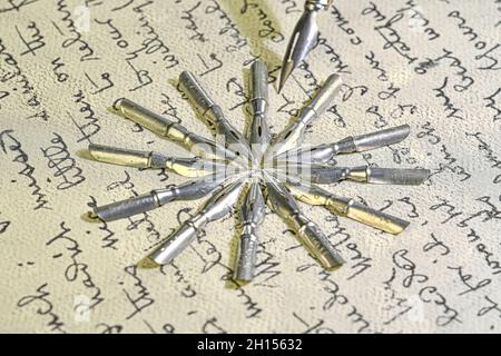 Nahaufnahme von Metallspitzen und altem Stift auf Vintage-Handschrift. Füllfederhalter auf einem alten handgeschriebenen Brief. Alte Geschichte. Retro-Style Stockfoto