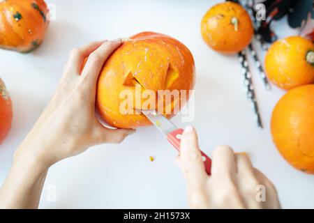Halloween am 31. Oktober. Der Schritt-für-Schritt-Prozess des Schnitzens eines Kürbisses. Blick von oben Stockfoto