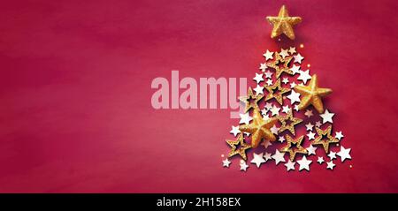 Weihnachten und Neujahr roter Hintergrund mit Weihnachtsbaum aus goldenen und hölzernen Sternen Stockfoto